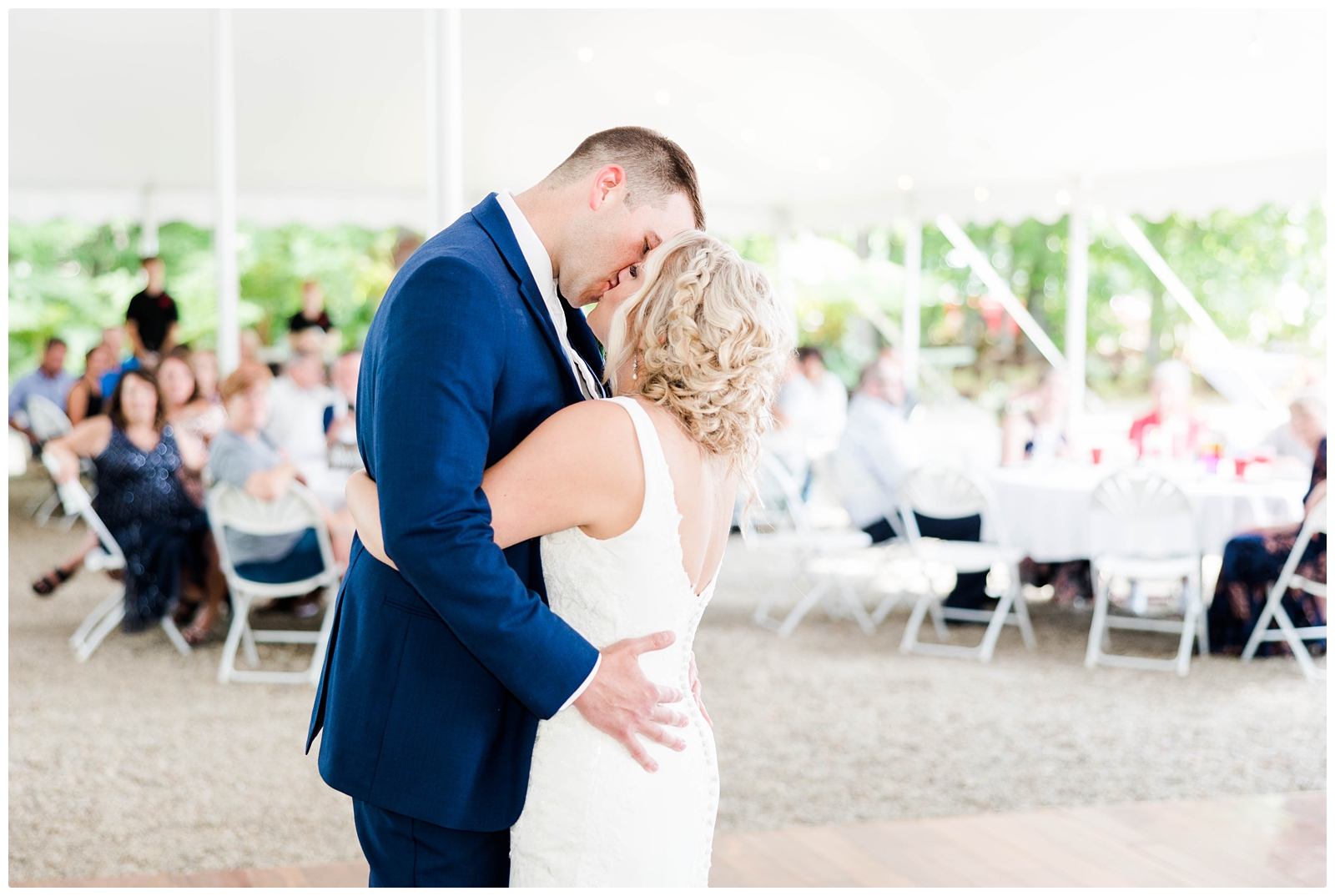 bride and groom first dance at wedding reception under tent