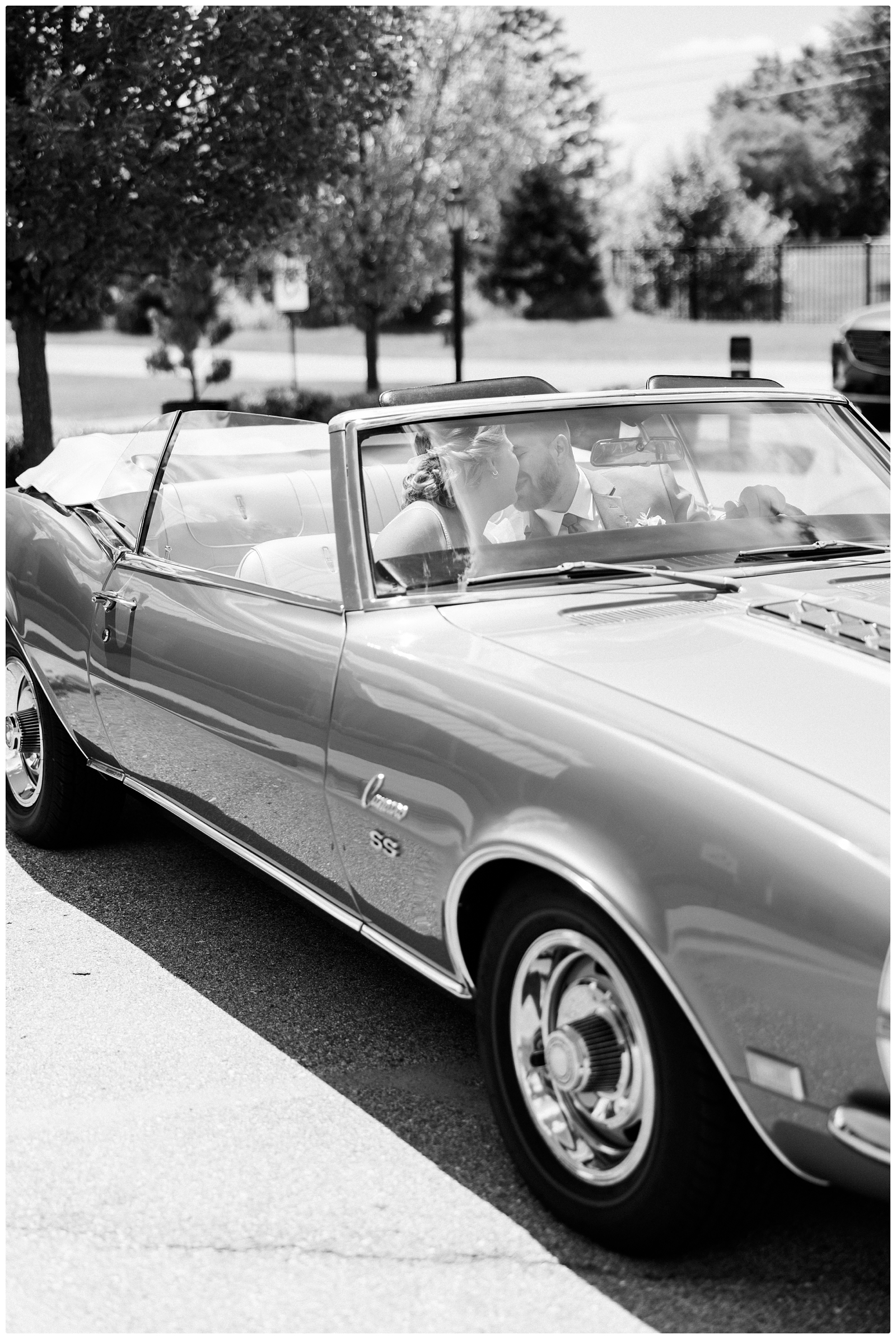 bride and groom kissing in car