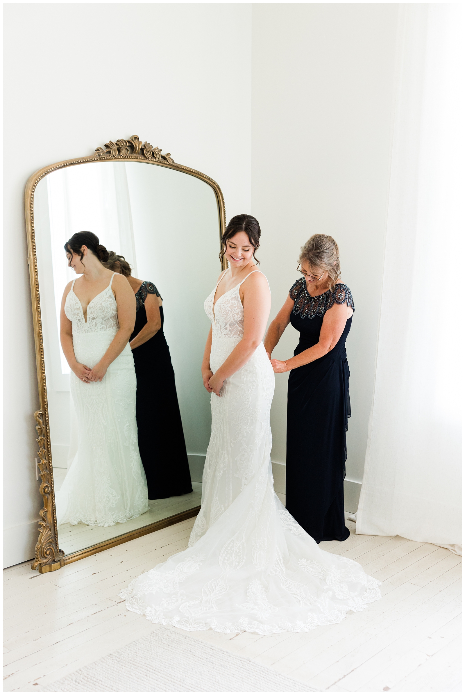 mother helping bride in dress