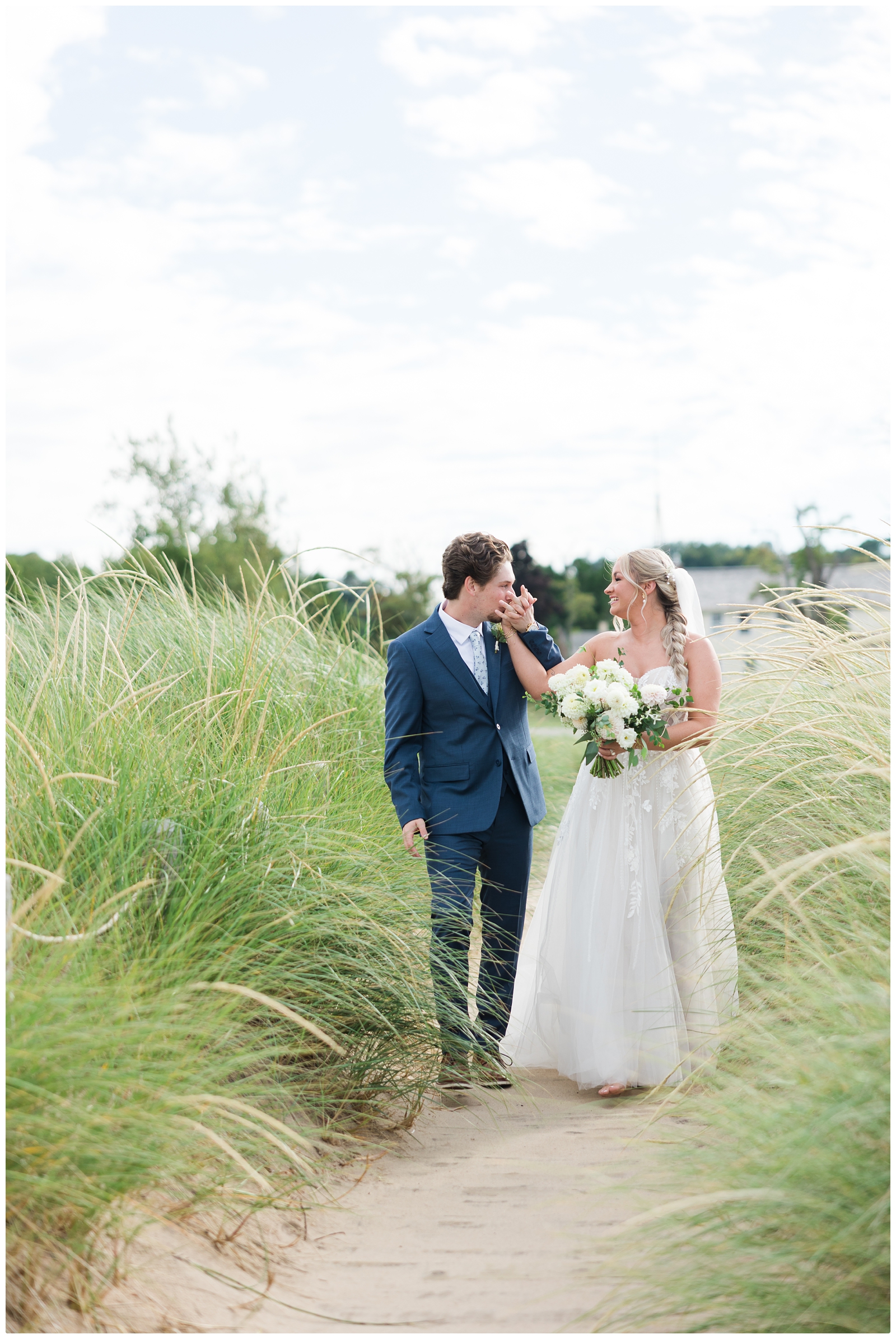 groom kissing brides hand at their lake michigan elopement